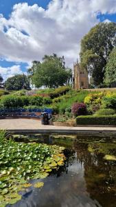 a pond with lilies in front of a building at Quaint Cottage in Charming Evesham in Evesham