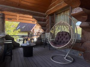 a hammock on a porch of a log cabin at Villa ZRUB in Palyanytsya