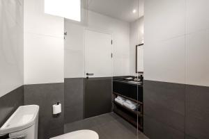 a bathroom with a white toilet and a sink at Prano Hotel in Bangkok