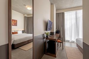 a hotel room with a bed and a desk with a computer at Prano Hotel in Bangkok +46 photos