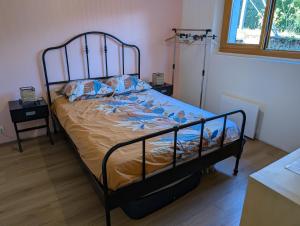 a bedroom with a bed with a metal frame at Chambres indépendantes chez l'habitant in Saint-Pierre-dʼAlbigny
