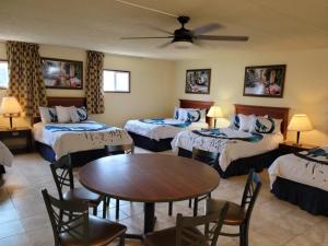 a hotel room with four beds and a table at Wolf Inn Hotel in Sandusky