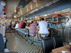 a group of people sitting at a bar in a restaurant at Wolf Inn Hotel in Sandusky +9 photos