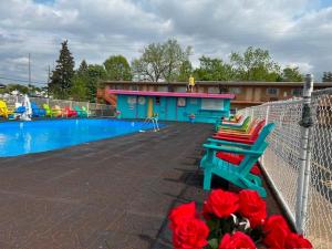 a fence with two benches next to a swimming pool at Wolf Inn Hotel in Sandusky