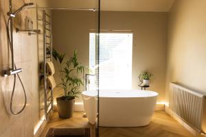 a bathroom with a bath tub and a window at The Byre in Penrith +25 photos