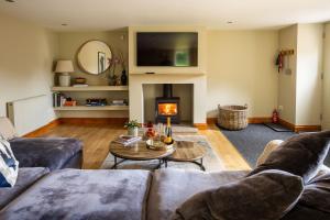 a living room with a couch and a fire place at The Byre in Penrith