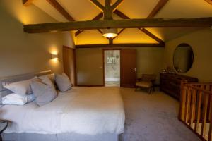a bedroom with a large white bed and a mirror at The Byre in Penrith