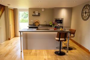 a kitchen with a large island with two bar stools at The Byre in Penrith