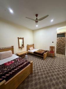 a bedroom with two beds and a ceiling fan at MANOKUR - E- BASA HOTEl in Minapin