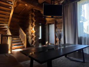 a living room with a table and a tv on the wall at Villa ZRUB in Palyanytsya