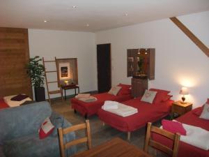 a living room with red couches and a couch at Le Domaine du Grand Cellier Chambres d'hôtes en Savoie in Tournon +38 photos
