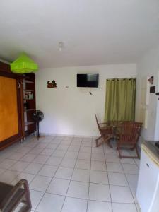 a living room with a television and a tiled floor at Kaz A Ti Jo in Petit-Bourg