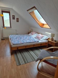 a bedroom with a bed with a window in it at Naplopó-lak in Ábrahámhegy