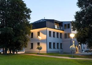 a large white building with a black roof at Otepää Residence in Otepää