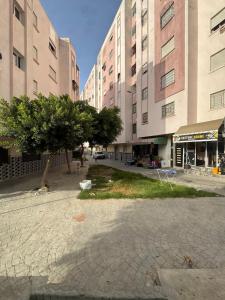 a building with a tree in the middle of a street at Perfect Stay Apartment 10 min to airport ibn battouta and beach in Tangier