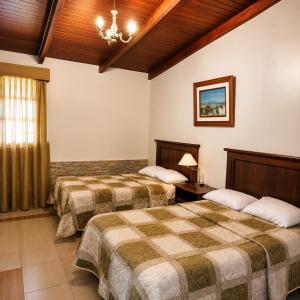 a hotel room with two beds and a chandelier at Hosteria Quinta Aidita in Guano