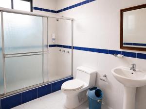 a bathroom with a shower and a toilet and a sink at Hosteria Quinta Aidita in Guano