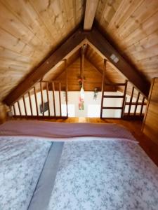 a large bed in a room with a wooden ceiling at Tinyhouse Loisl in Thyrnau +8 photos