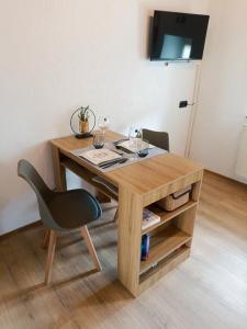 a wooden table with a black chair and a desk at Tinyhouse Loisl in Thyrnau