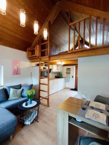 a living room and kitchen with a loft bed at Tinyhouse Loisl in Thyrnau