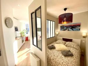 a bedroom with a bed and a clock on the wall at Le Vivaldi - Studio Hypercentre Saint-Étienne in Saint-Étienne