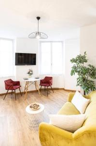 a living room with a yellow couch and a table at Le Vivaldi - Studio Hypercentre Saint-Étienne in Saint-Étienne