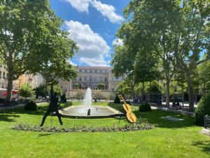 a park with a fountain in front of a building at Le Vivaldi - Studio Hypercentre Saint-Étienne in Saint-Étienne