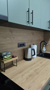 a kitchen counter with a tea kettle and a table at Vozd Apartment in Belgrade