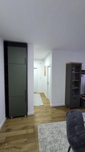 an empty living room with a door and a chair at Vozd Apartment in Belgrade