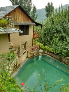 a small swimming pool in front of a house at Orchard Huts in Chamba