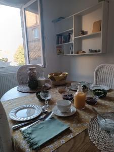 a table with plates and utensils on top of it at Villa Colomba - Chambre Paloma in Dunkerque