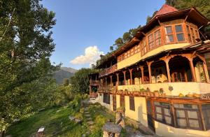 a large building on top of a hill at Orchard Huts in Chamba