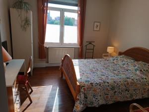 a bedroom with a bed and a window at Villa Colomba - Chambre Paloma in Dunkerque