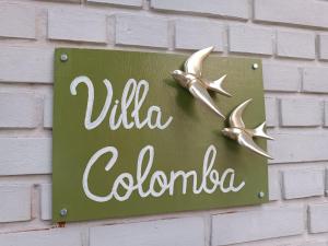 a sign on a brick wall with two birds on it at Villa Colomba - Chambre Paloma in Dunkerque