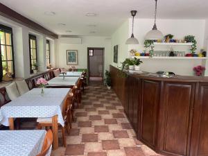 a dining room with two tables and a bar at Penzion Janata in Slapy