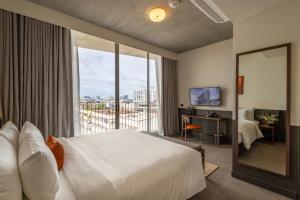 a hotel room with a bed and a large window at Prano Hotel in Bangkok