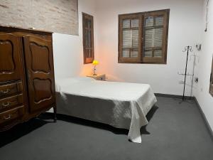 a bedroom with a bed and a dresser and a window at Apart Santa Ana in Santa Ana