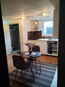ein Wohnzimmer mit einem Tisch und einer Küche in der Unterkunft Central Studio Sollefteå in Sollefteå