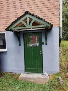 eine grüne Tür an der Seite eines Hauses in der Unterkunft Central Studio Sollefteå in Sollefteå