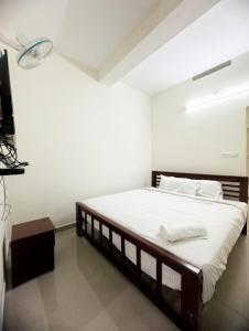 a bedroom with a large bed and a television at Skybz Resort - Mankulam in Viripara