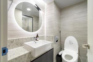 a bathroom with a sink and a toilet and a mirror at 플럼바고올스위트1107 in Chosan-ni