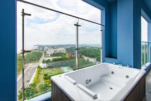 a bath tub in a bathroom with a large window at 플럼바고올스위트1107 in Chosan-ni