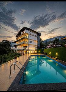 a large swimming pool in front of a building at Skybz Resort - Mankulam in Viripara