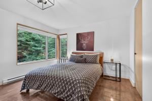 a bedroom with a bed and a large window at Welcome to La Cabine de Charlevoix in Petite-Rivière-Saint-François