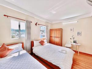a bedroom with two beds and a window at Mie House Da Lat in Xuan An