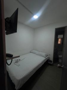 a bedroom with a bed and a tv on the wall at Hotel sahara in Medellín +5 photos