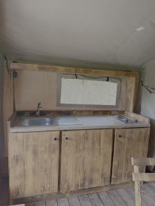 a kitchen with a sink and a window in a trailer at Dworska Polana in Szteklin