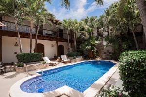 a swimming pool in a courtyard with palm trees at Hotel Plaza Colon - Granada Nicaragua in Granada