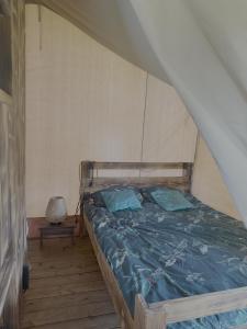 a bed with blue sheets in a room at Dworska Polana in Szteklin