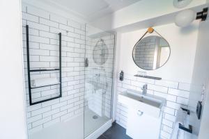 a white bathroom with a shower and a sink at Ibis Centre Millau in Millau +31 photos